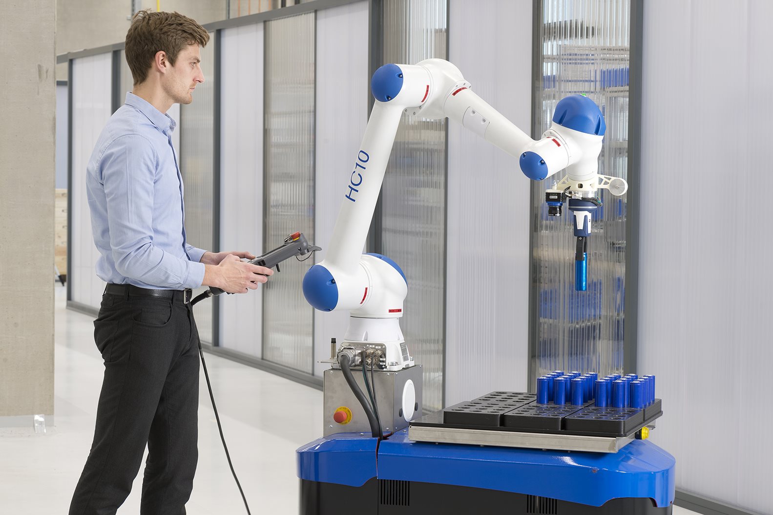 Mitarbeiter arbeitet mit einem Cobot in der Roboterhalle des Fraunhofer IGCV