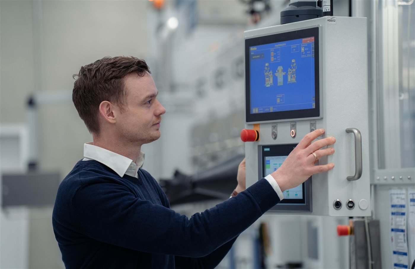 Mitarbeiter bedient den Touchscreen einer Anlage